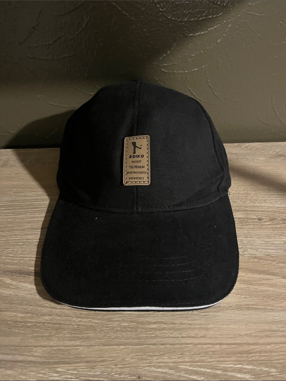 Black Baseball Cap With a Brown Logo And Adjustable Strap